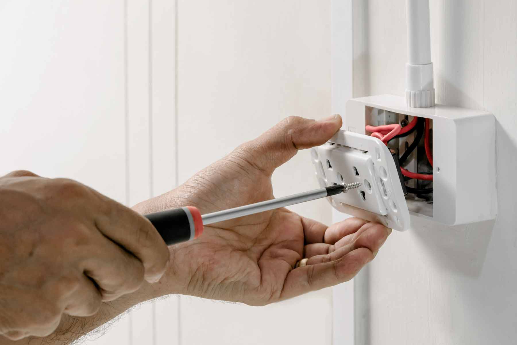 Electrician repairing electrical outlet